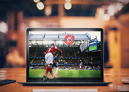 Computer on a table displaying a football match.