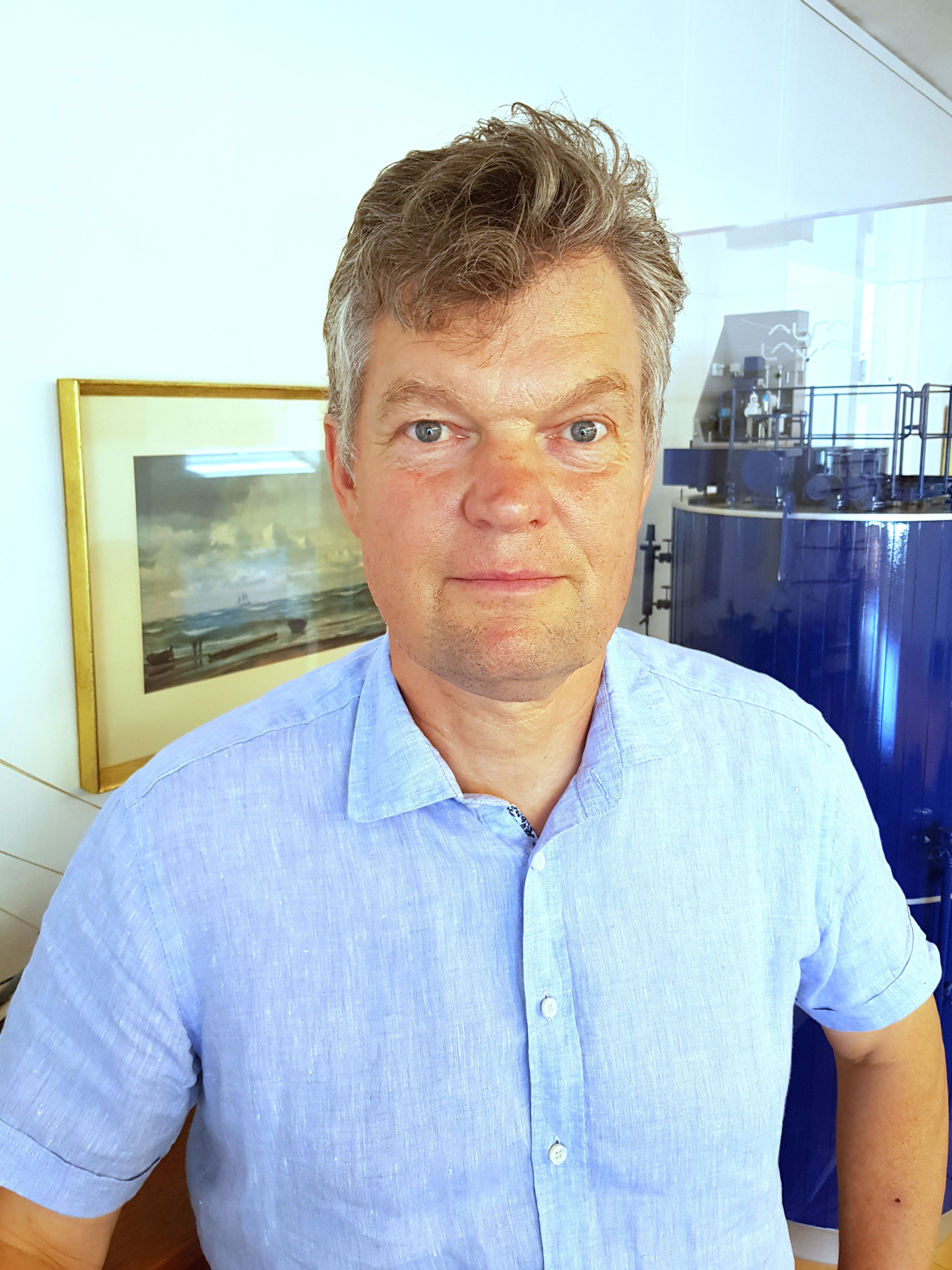 Close-up of a man infront of a miniatyr ship